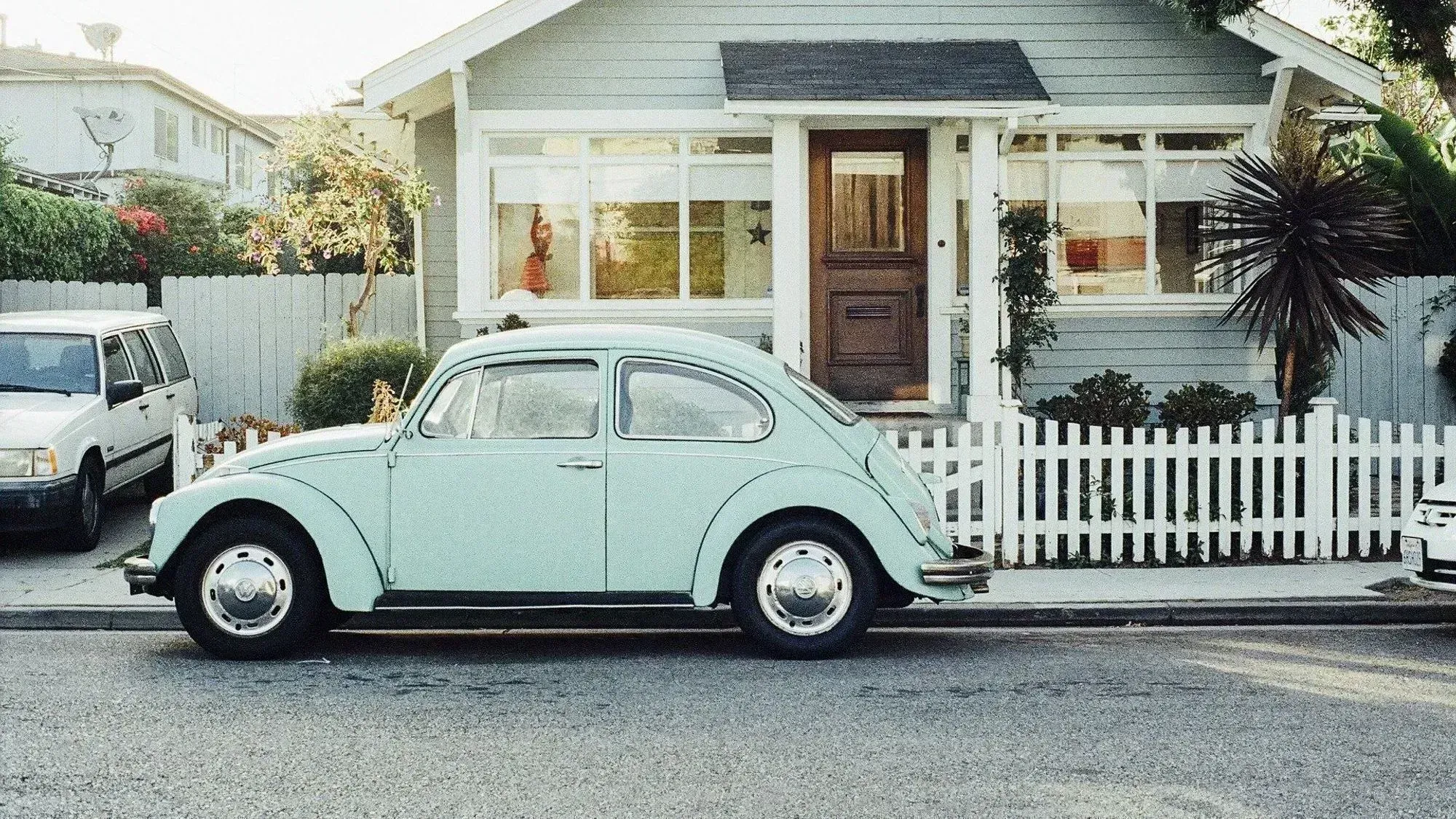 Fusca em frente a uma casa.